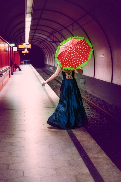 Frau mit Schirm in U-Bahn